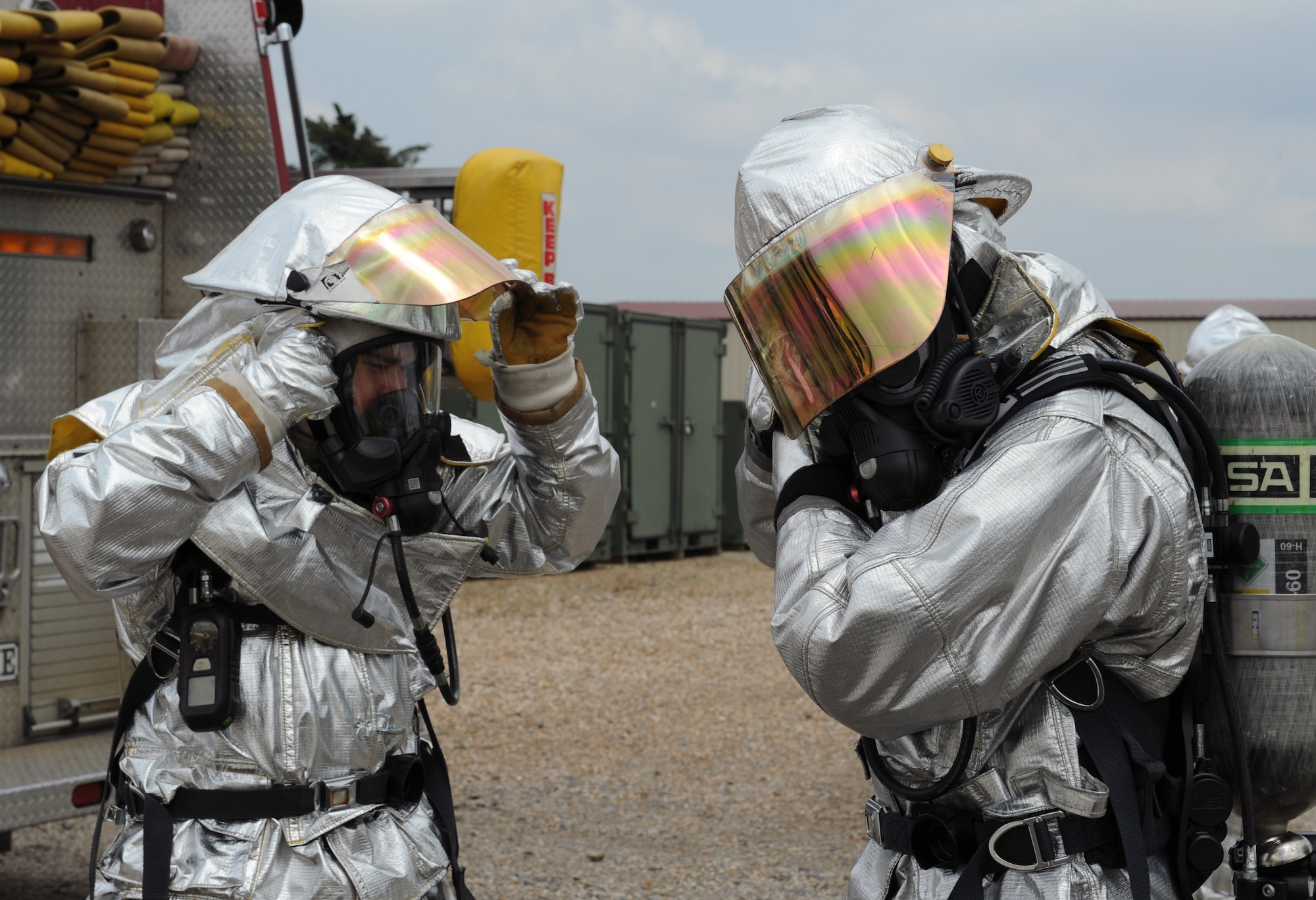 Firefighters from the 2nd Civil Engineer Squadron remove parts of their equipment before a radiation contamination check on Barksdale Air Force Base, La., May 17, 2013. Airmen from the 2nd CES and 2nd Aerospace Medicine Squadron bioenvironmental conducted a joint exercise to give Airmen hands on experience on how to handle aircraft accidents with strategic weapons on board. (U.S. Air Force photo/Airman 1st Class Benjamin Gonsier)
