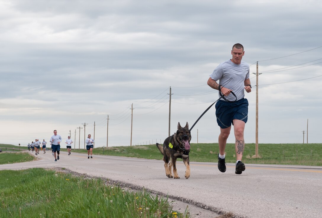 Staff Sgt. Jacob Brown, 28th Security Forces Squadron military working dog handler, runs with his partner Boris, during the Police Week 5k at Ellsworth Air Force Base, S.D., May 16, 2013. Members of Ellsworth participated in the run to show their support for fallen officers that sacrificed their lives to protect the freedoms of others. (U.S. Air Force photo by Airman 1st Class Alystria Maurer/Released)