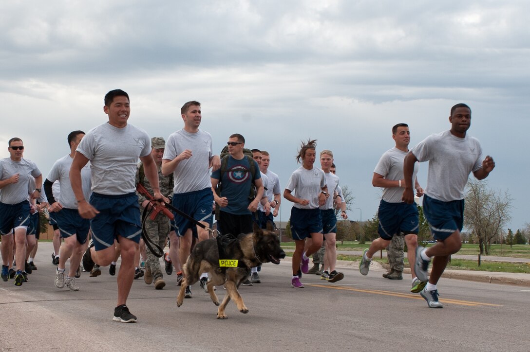 Staff Sgt. Otto Yan, 28th Security Forces Squadron military working dog trainer, and his dog Xarius, lead the pack at the beginning of the Police Week 5k at Ellsworth Air Force Base, S.D., May 16, 2013. The run started at the Bellamy Fitness Center, looped around the 28th SFS firing range and ended at the BFC. (U.S. Air Force photo by Airman 1st Class Alystria Maurer/Released)