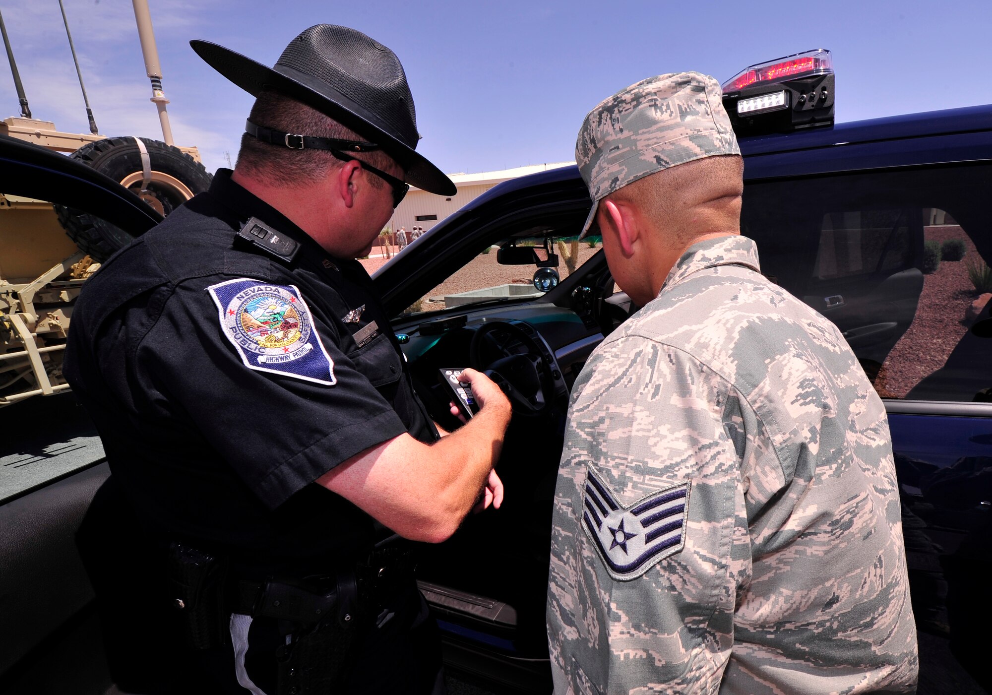 LAS VEGAS, Nev. -- A Nevada Highway Patrolman shows an Airman his radar system during a static display demonstration as part of National Police Week, May 14, 2013. In addition to the Nevada Highway Patrol, members of the 99th Ground Combat Training Squadron showcased various Air Force assets. National Police Week was established in 1962 to honor the service and sacrifices of past and present members of U.S. law enforcement agencies.  (U.S. Air Force photo by Staff Sgt. A.D./Released)