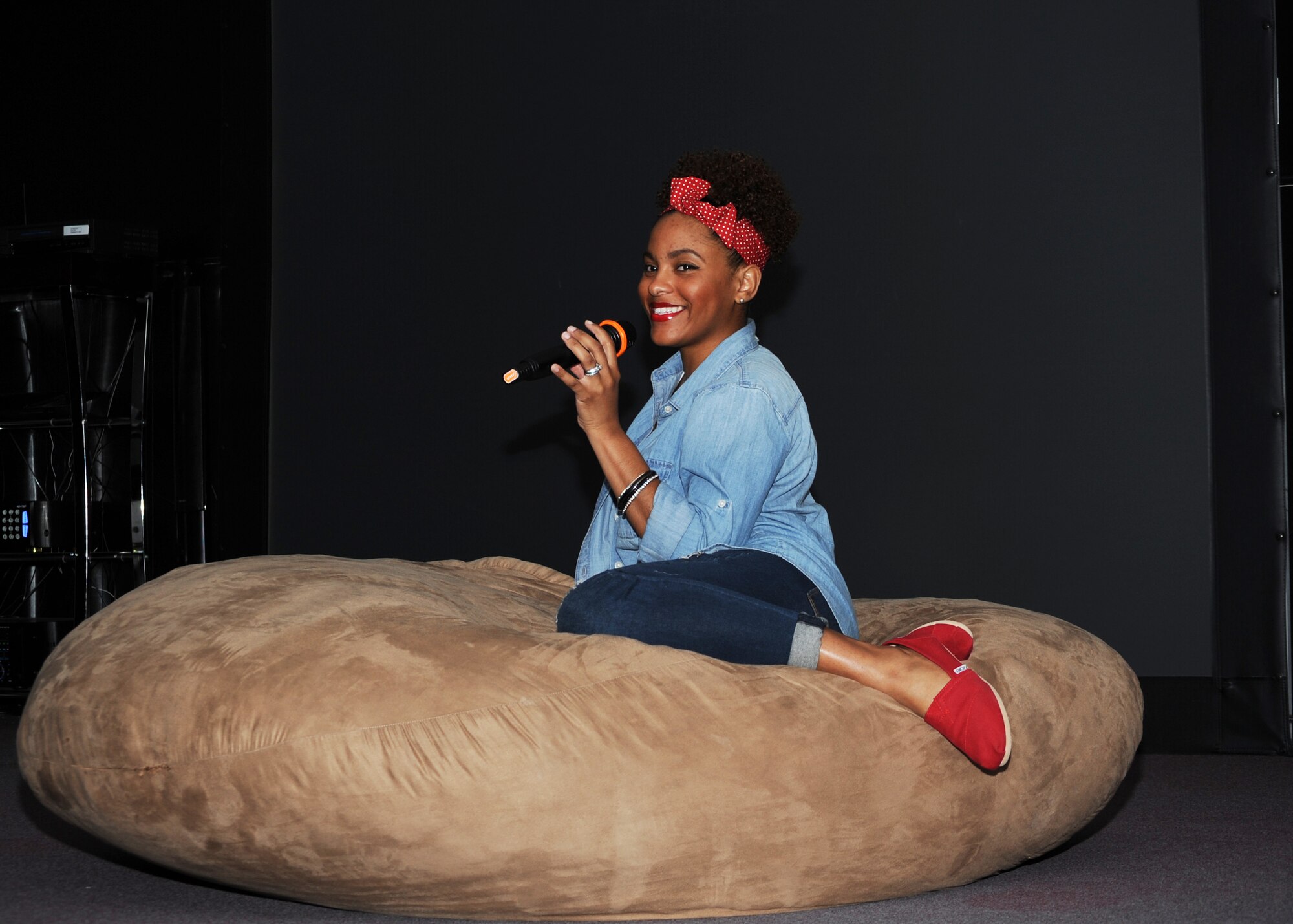 U.S. Air Force Tech. Sgt. Candice Fagan, 56th Special Operations Intelligence Squadron mission coordinator, smiles for the crowd as she pauses for emphasis in her rendition of a current top 10 pop song at Cannon Air Force Base, N.M., May 17, 2013. The Community Center hosts Karaoke Friday Nights every Friday from 8 p.m. to 3 a.m. (U.S. Air Force photo/Desiree Ann Montenegro)