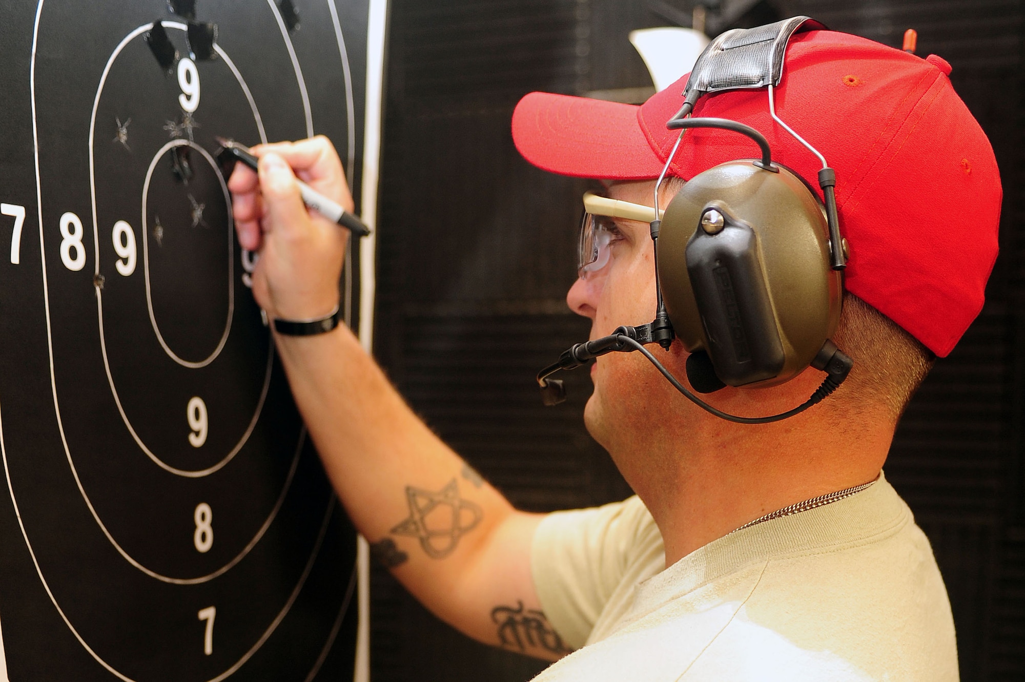 U.S. Air Force Tech. Sgt. Trevor Mercer, 4th Security Forces Squadron physical security NCO in-charge, scores a competitor’s target during an excellence-in-competition pistol match on Seymour Johnson Air Force Base, N.C., May 14, 2013. Participants shot a total of 40 rounds at targets 25 yards down range. (U.S. Air Force photo by Airman 1st Class John Nieves Camacho/Released)