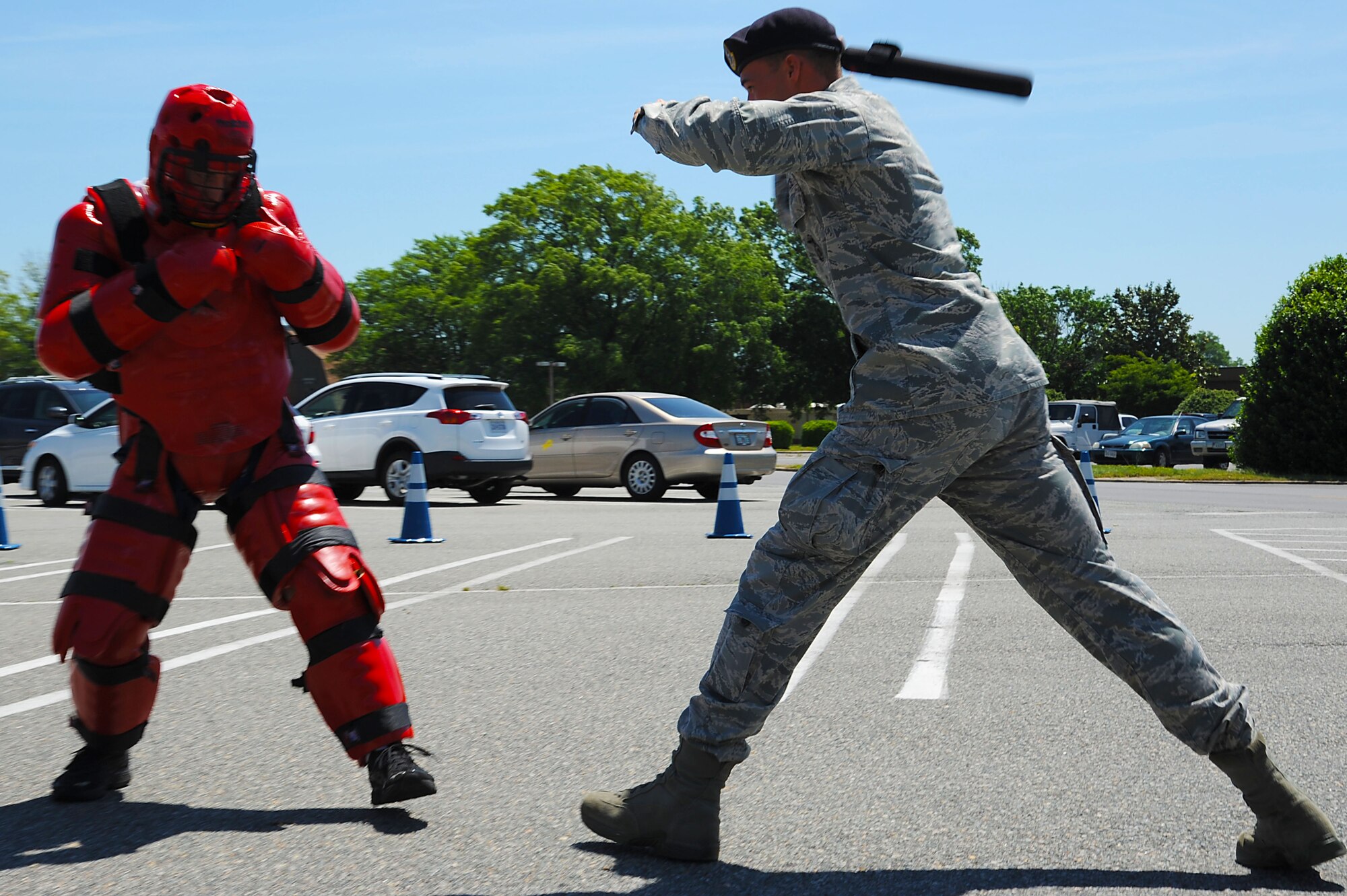 Senior Airman James Grabinski, 633rd Security Forces Squadron Krav Maga instructor, forcefully strikes Staff Sgt. Kelly Eaton, 633rd Security Forces Squadron Krav Maga instructor, with a baton during a demonstration for Police Week at Langley Air Force Base, Va., May 16, 2013. The red suit worn in the demonstration is designed to protect against any hit from the baton. (U.S. Air Force photo by Airman 1st Class Victoria H. Taylor/Released)