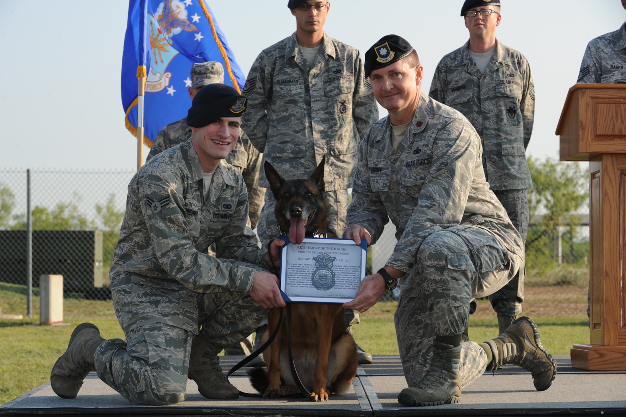 GOODFELLOW AIR FORCE BASE, Texas -- Senior Airman Donald Weaver, 17th Security Forces Squadron military working dog hander and Longo, 17th SFS MWD, receive a retirement of the badge certificate from Maj. Dennis Turriff, 17th SFS commander, during a retirement ceremony for Karin and Longo at the base kennel, May 14. Longo, a 9-year-old Belgian malinois, was assigned to Goodfellow in January 2006. (U.S. Air Force photo/ Staff Sgt. Laura R. McFarlane)