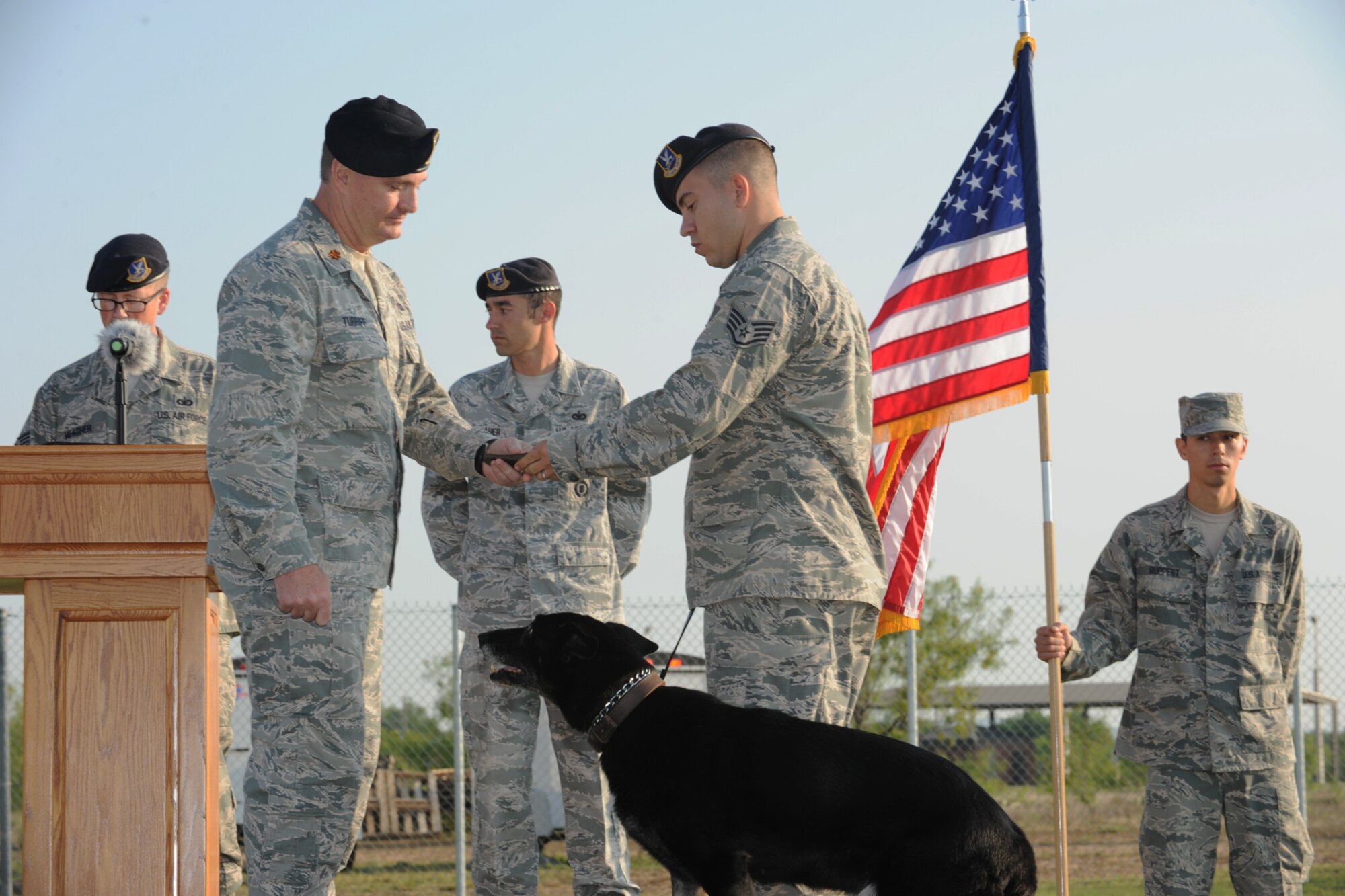 GOODFELLOW AIR FORCE BASE, Texas -- Maj. Dennis Turriff, 17th Security Forces Squadron commander, accepts a badge for Karin, 17th SFS military working dog, from Staff Sgt. Tyler Wiseman, 17th SFS MWD handler, during a retirement ceremony for the 17th SFS MWDs at the base kennel May 14. Karin, an 8-year-old German shepherd, was assigned to Goodfellow in September 2008.  (U.S. Air Force photo/ Staff Sgt. Laura R. McFarlane)