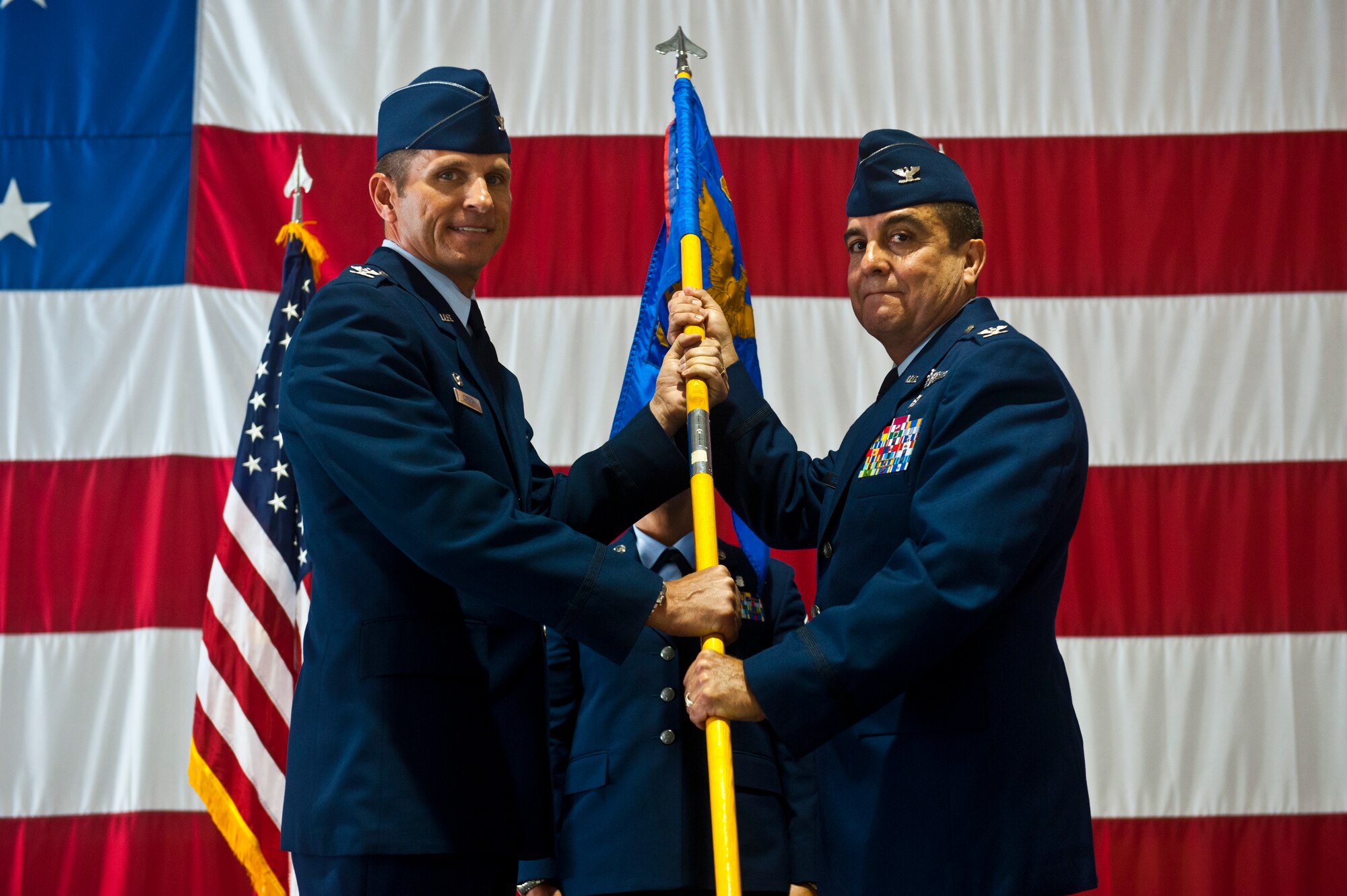 Col. Guillermo Tellez, 99th Medical Group commander, accepts the MDG’s guidon from Col. Barry Cornish, 99th Air Base Wing commander, during the 99th MDG change of command ceremony May 17, 2013, inside the Thunderbird Hangar at Nellis Air Force Base, Nev. The 99th MDG provides medical care to Department of Defense beneficiaries and veterans to ensure maximum wartime readiness and combat capability. (U.S. Air Force photo/Senior Airman Brett Clashman)
