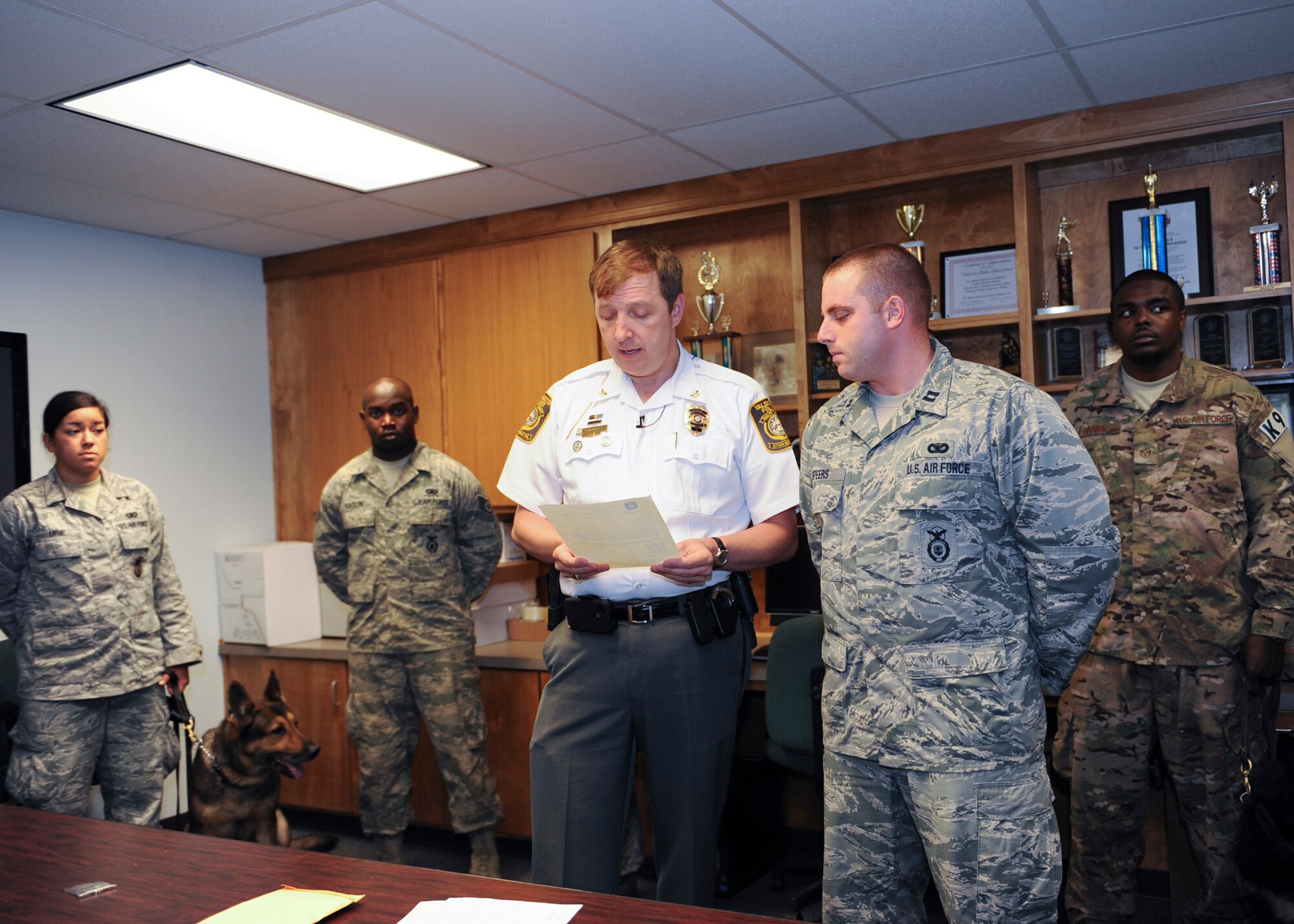 Brian Childress, Valdosta Police Department (VPD) chief of police, reads a letter of appreciation to members of Moody Air Force Base, Ga., at the VPD May 17, 2013. After a bomb threat at a local high school, the VPD requested assistance from Moody military working dogs to search the school for explosives. All personnel that responded to the incident were coined as a token of appreciation from the VPD. (U.S. Air Force photo by Senior Airman Eileen Meier/Released)