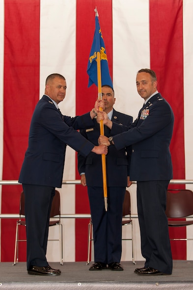 Col. Floyd Dunstan, commander, 140th Wing, passes the 140th Operations Group guidon to newly-promoted Col. Timothy Conklin, the new 140 OG commander, during a ceremony May 18 at Buckley AFB, Colo. (U.S. Air National Guard photo by Tech. Sgt Wolfram Stumpf)