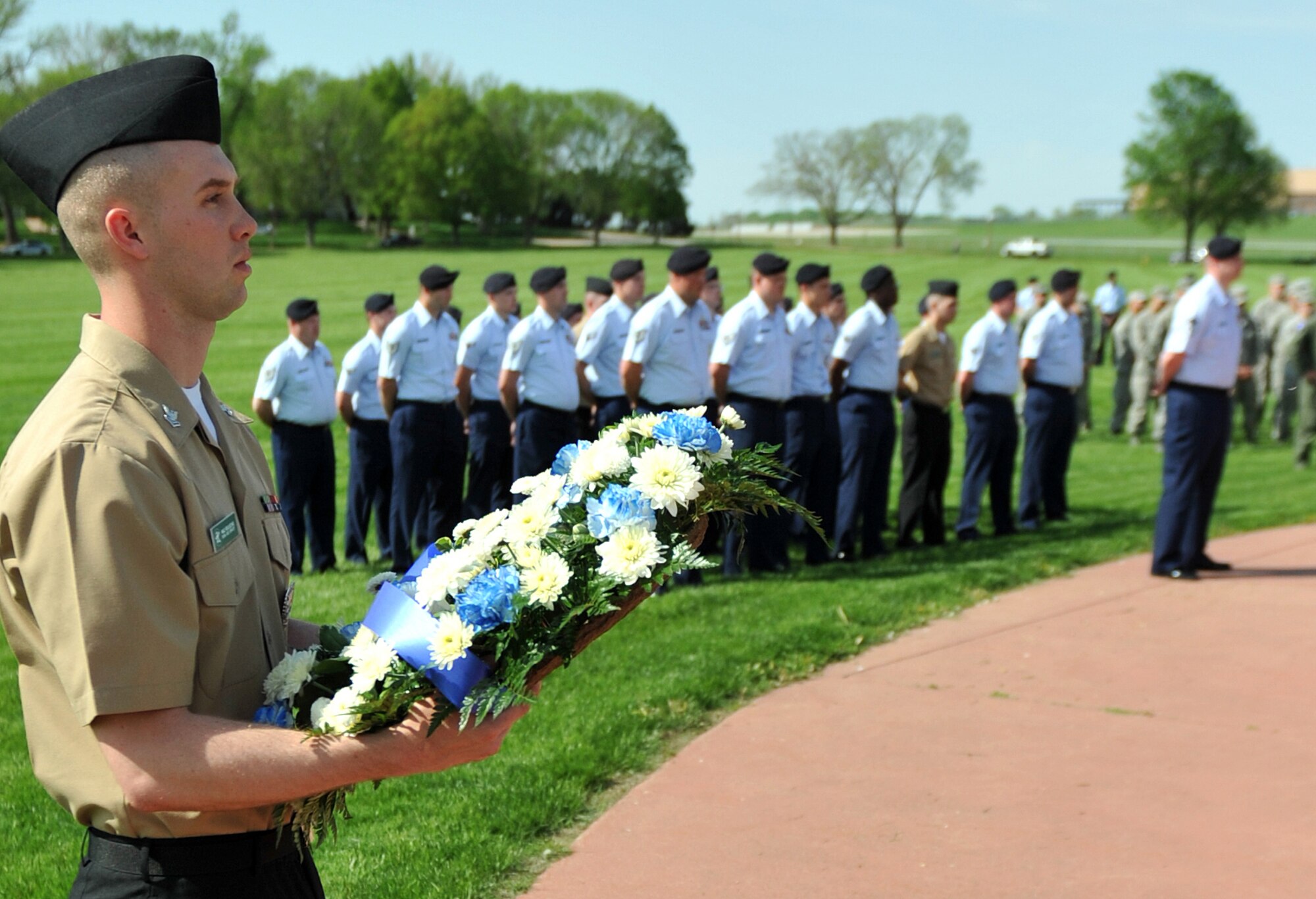 U.S. Navy Petty Officer 2nd Class, Levi Reulecke, a master-at-arms with the 55th Security Forces Squadron, stands at attention awaiting the presentation on the wreath during the Police Week Retreat Ceremony at Offutt Air Force Base, Neb. May 16. The wreath is traditionally presented before guests, paying tribute to law enforcement officers who were lost in the line of duty. (U.S. Air Force photo by Jeff W. Gates/Released)
