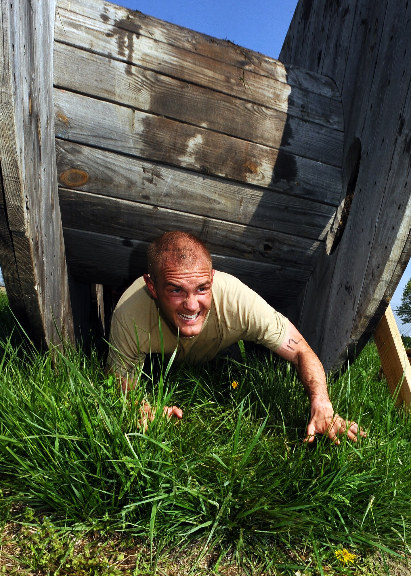 U.S. Air Force Tech Sgt. Joseph Cook, NCO in charge of the 55th Security Forces Squadron’s Training Section, crawls out from under a cable spindle as he and his team make their way to the finish line of the Police Week Evasion Challenge on May 16, Offutt Air Force Base, Neb. The obstacle course had several teams representing Offutt’s multiple military branches and commands.  (U.S. Air Force photo by Josh Plueger)