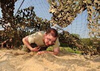 U.S. Air Force Airman 1st Class Ron Sparkman, a computer programmer with the 55th Strategic Communications Squadron, low crawls his way through thick sand as he and the SCS team make their way toward the final portion of the Police Week Evasion Challenge held on May 16, Offutt Air Force Base, Neb. The third leg of the Evasion Challenge tested the already exhausted participants’ physical and mental toughness. (U.S. Air Force photo by Josh Plueger/Released)