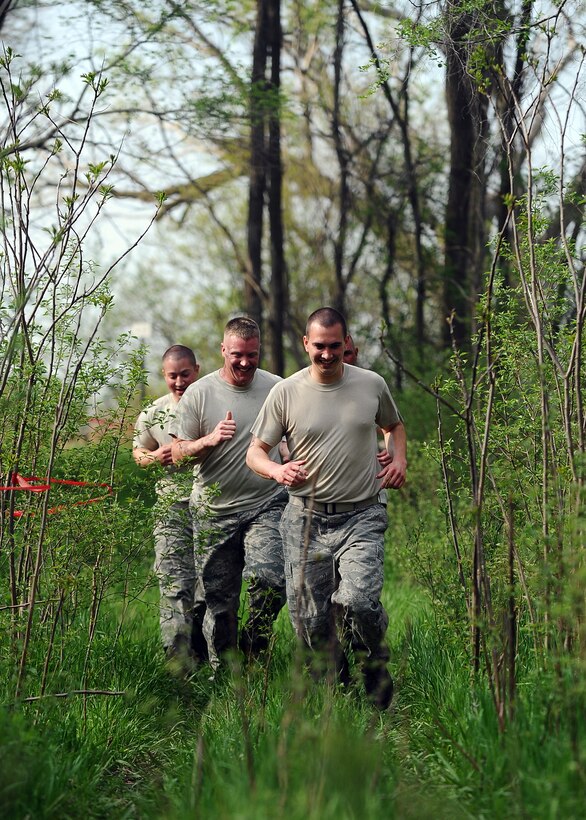 The 55th Logistics Readiness Squadron’s Petroleum, Oils and Lubricants Flight team runs through a wooded area to at the start of the three-mile Police Week Evasion Challenge obstacle course held on May 16, Offutt Air Force Base, Neb.  Teams of no more than four members competed in this physically challenging camaraderie-building event. (U.S. Air Force photo by Josh Plueger/Released)