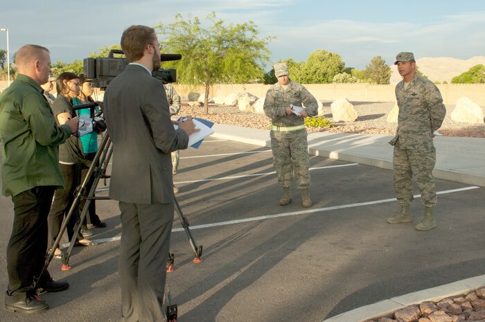 Col. Barry Cornish, 99th Air Base Wing commander, and Master Sgt. David Miller, 99th ABW public affairs community outreach specialist, respond to questions posed by simulated civilian media during a press conference held as part of an exercise May 16, 2013, at Nellis Air Force Base, Nev. The simulated press conference was held to ensure members of the media had accurate and timely information about the conditions on base. (U.S. Air Force photo by Staff Sgt. Gregory Brook)