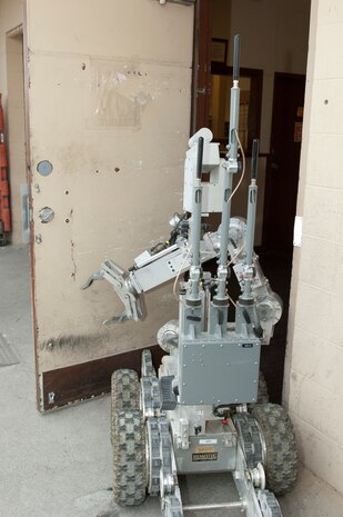 A Remotec Andros F-6 robot opens the door to a room containing a suspicious package as part of an exercise May 16, 2013, at Nellis Air Force Base, Nev. The robot is operated from a remote location by explosive ordinance disposal technicians to allow investigation of an incident without endangering servicemembers. (U.S. Air Force photo by Staff Sgt. Gregory Brook)