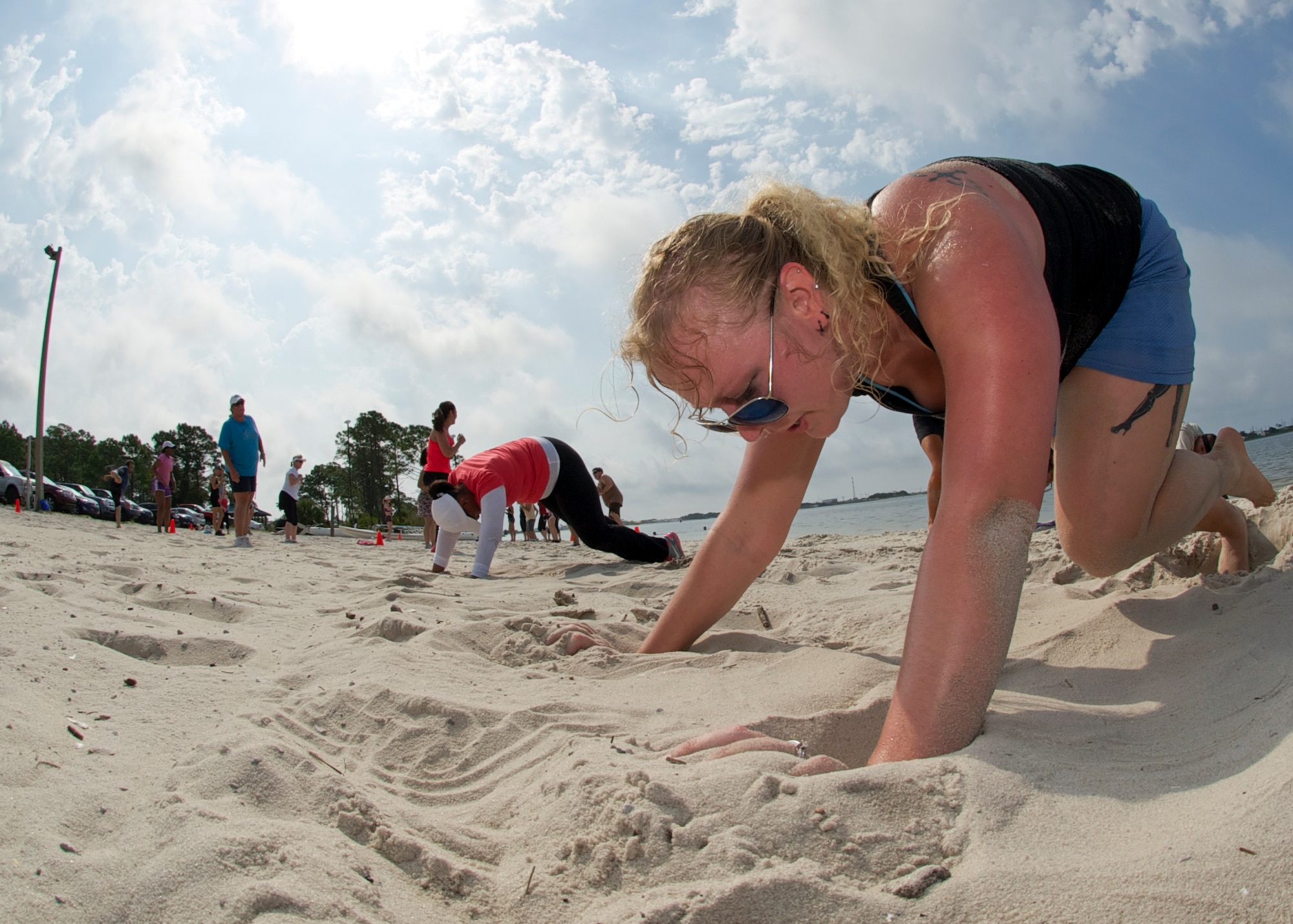 Kayla Camp, spouse of Tech. Sgt. Eric Camp, crawls through the sand during beach boot camp at the Soundside Beach on Hurlburt Field, Fla., May 18, 2013. Beach boot camp challenged participants to physically and mentally push themselves to accomplish several aerobic and strength training circuits. (U.S. Air Force Photo/ Staff Sgt. John Bainter)