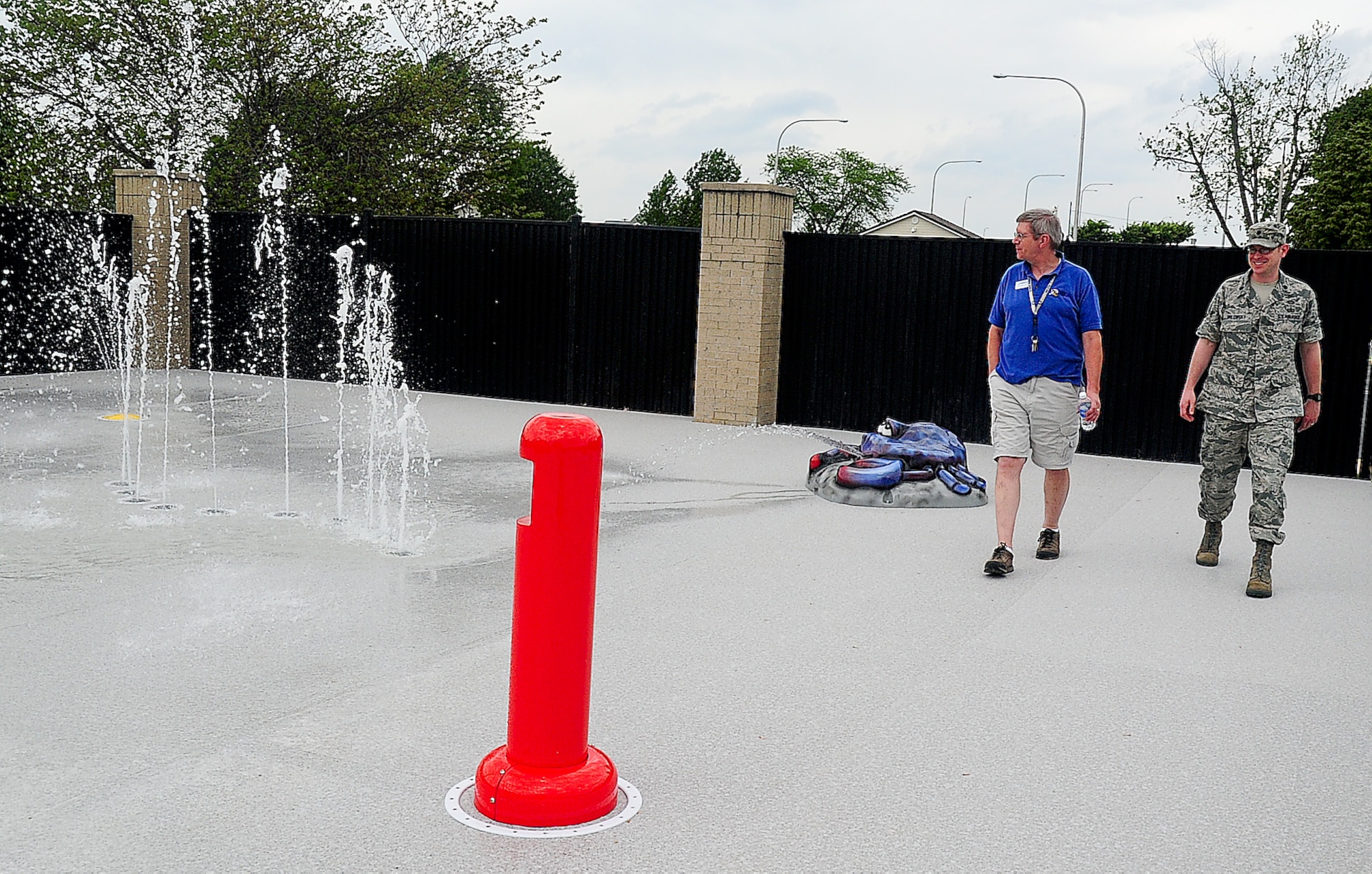 Chris Smith, Outdoor Recreation manager, walks with Lt. Col. Matt Orlowsky, 436th Force Support Squadron commander, May 16, 2013, at the Oasis Pool on Dover Air Force Base, Del. Smith showed Orlowsky the new addition to the pool, the splash pad. (U.S. Air Force photo/Airman 1st Class Ashlin Federick)