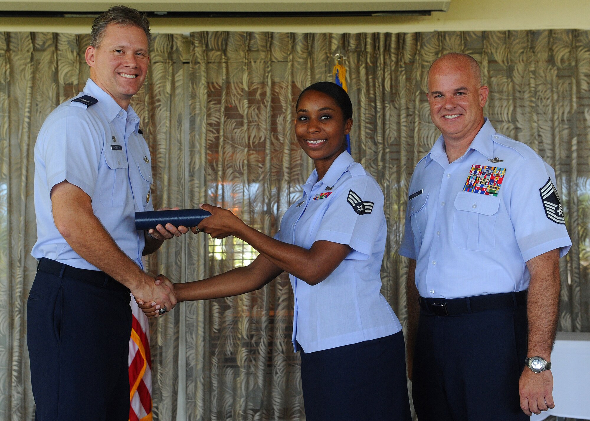 Col. Dan Baldessari, 15th Operations Group commander, left, and Chief Master Sgt. Michael Morris, 15th Operations Group chief, present a Community College of the Air Force degree to Senior Airman Mavis Jones, 15th Wing commander support staff non-commissioned officer-in-charge, at the Officer Club, Joint Base Pearl Harbor-Hickam, Hawaii, May 17, 2013.  Jones along with 100 other Airmen received their CCAF’s degrees during a ceremony presided over by Baldessari, demonstrating one of the Wing’s top priorities of developing our Airmen. (U.S. Air Force photo/Tech. Sgt. Jerome S. Tayborn)