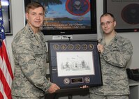 Lt. Gen. Stephen Hoog, 11th Air Force commander presents the 11th AF company grade officer of the year award to Capt. John R. Robbins, 747th Communications Squadron operations flight commander, at the 747th CS squadron at Joint Base Pearl Harbor-Hickam, Hawaii, May 17, 2013.  Robbins received the award for his exemplary leadership abilities helping to lead the men and women of the 747th CS. (U.S. Air Force photo/Tech. Sgt. Jerome S. Tayborn)