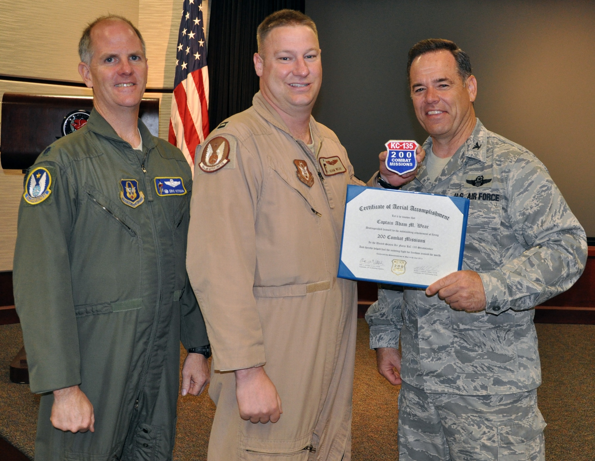 Lt. Col. Eric Vitosh, commander of the 18th Air Refueling Squadron, and Col. Mark S. Larson, commander of the 931st Air Refueling Group, present a certifcate and patch commemorating 200 combat sorties flown to Capt. Adam Wear, a pilot assigned to the 18 ARS, at McConnell Air Force Base, Kan., April 21, 2013. (U.S. Air Force photo by Capt. Zach Anderson)
