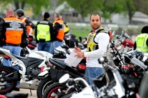 U.S. Air Force Tech. Sgt. Franz Bruce-Salmon, a USSTRATCOM production non-commissioned officer, pauses from reading his safety briefing before participating in the 55th Wing Mentorship Ride May 10 at Offutt Air Force Base, Neb. Bruce-Salmon was one of the Ride Captains who provided mentorship during the ride. More than 100 riders participated in the event that provided hands-on experience riding in groups over a span of 134 miles. Group riding is known to be an effective way to influence new riders on using safe practices.  (U.S. Air Force photo by Josh Plueger/Released)