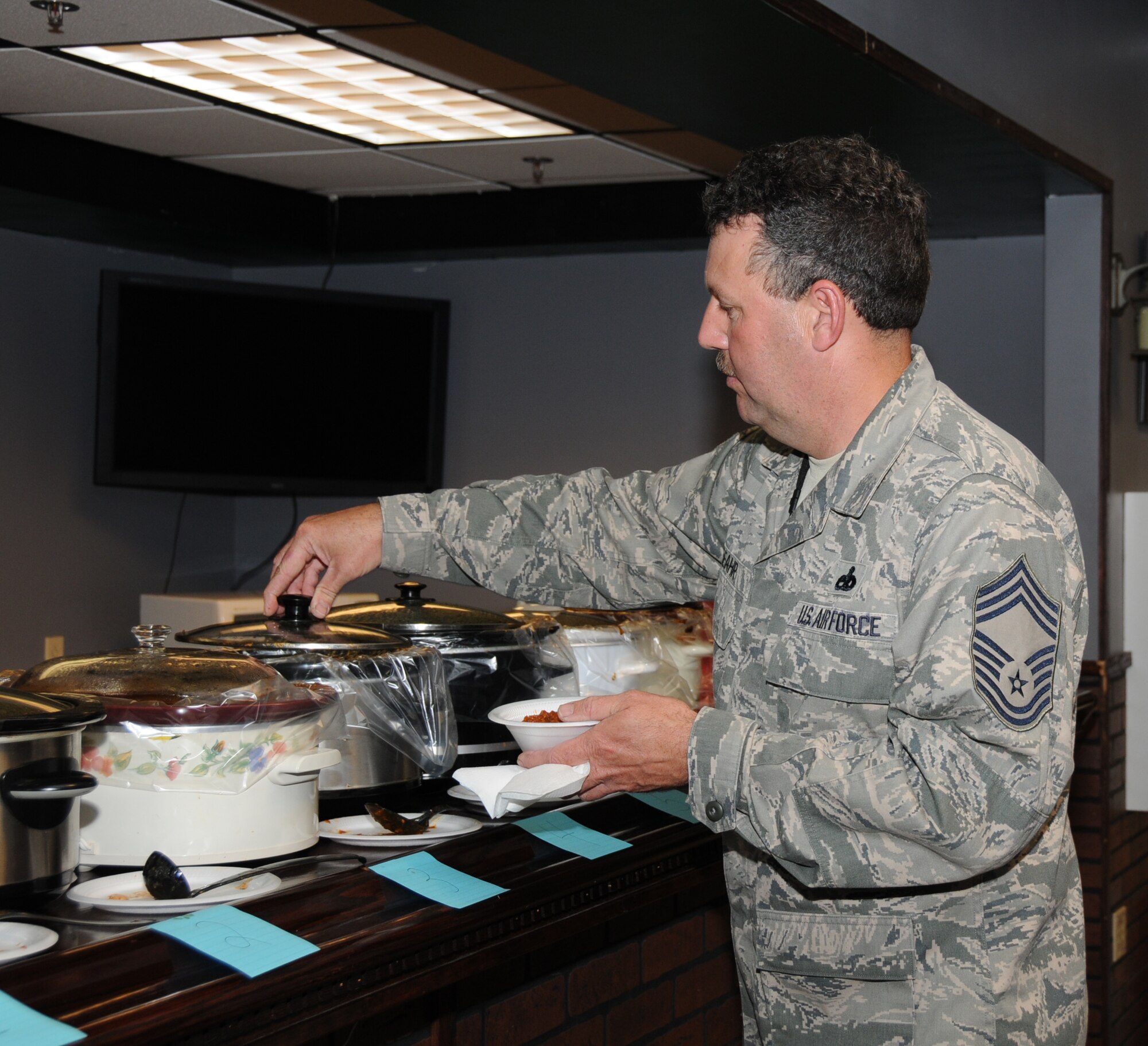 Chief Master Sgt. David L. Beahr, 192nd maintenance squadron superintendent, tries one of 12 varieties of chili at the second annual Chili Cook-off sponsored by the Advanced Programs Office, May 18, 2013. The cook-off was held for the American Cancer Society in honor of the late Master Sgt. Wesley "Chili" Childress, former VaANG member, who passed away from cancer in 2011. (U.S. Air National Guard photo by Master Sgt. Carlos J. Claudio/Released)
