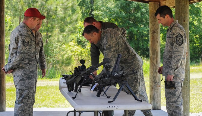 U.S. Air Force Col. Billy Thompson, 23d Wing Base commander, and Chief Master Sgt. Mathew Wells, 23d Wing command chief, look at a weapons display at Moody Air Force Base, Ga., on May 15, 2013. The weapons were on display to show the many different types that are available at Moody. (U.S. Air Force photo by Airman Alexis Grotz/ Released)