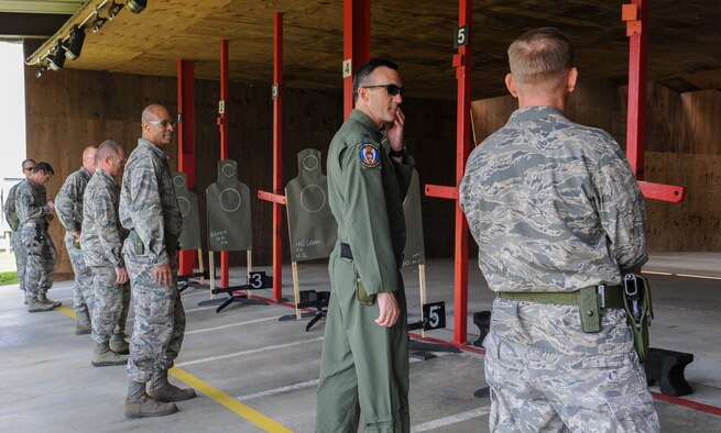 Base leadership lines up on the yellow line to participate in a shooting competition at Moody Air Force Base, Ga., May 15, 2013. The objective of the competition was to see who could score the most point by hitting the target in designated zones. (U.S. Air Force photo by Airman Alexis Grotz/ Released)