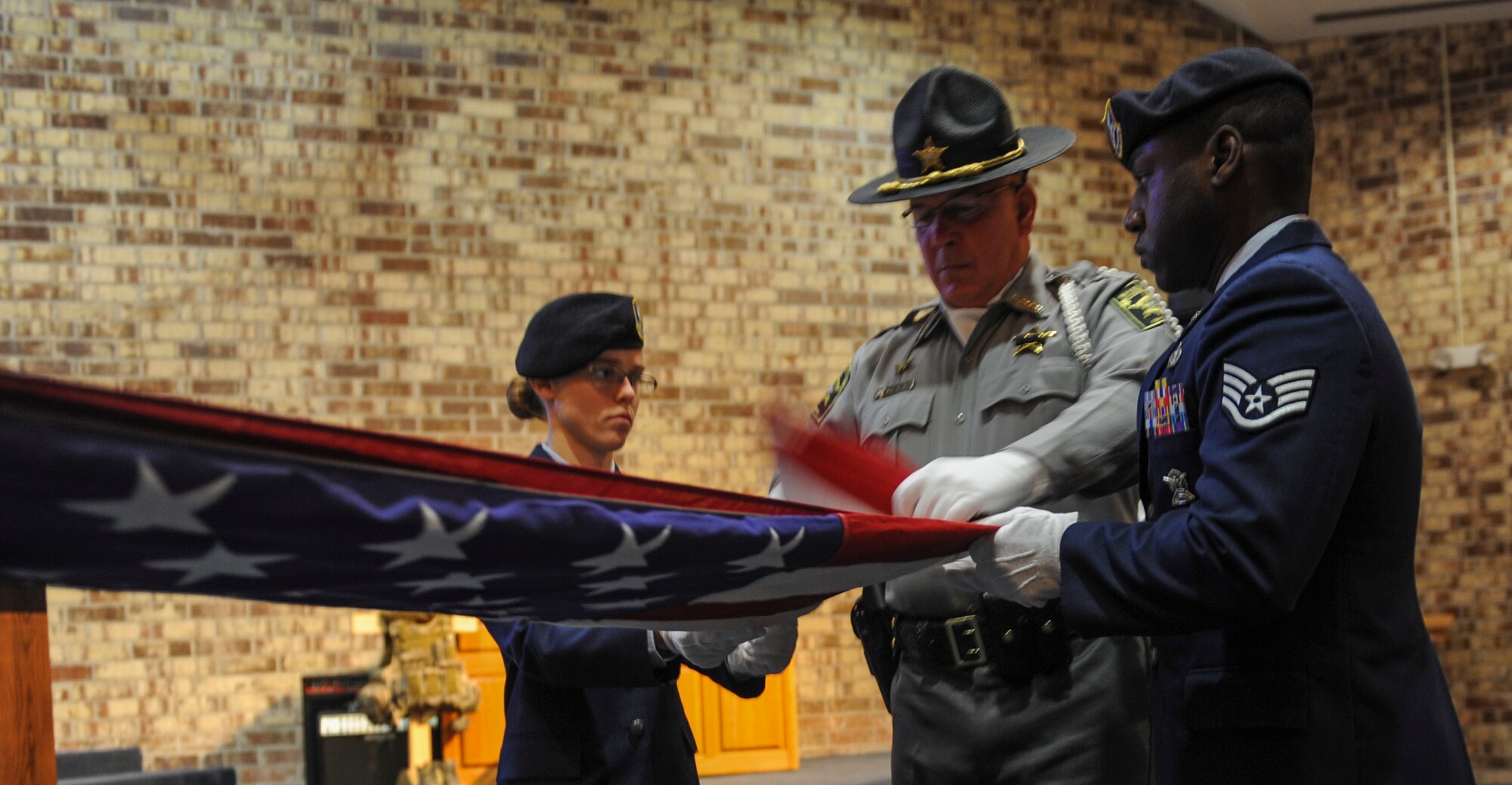 A Lowndes county Sheriff folds the flag with the help of two Airmen at Moody Air Force Base, Ga., May 15, 2013. The flag is folded and presented while taps is played in remembrance of all past, present and future law enforcement. (U.S. Air Force photo by Airman Alexis Grotz/ Released)