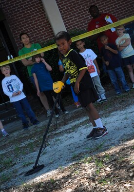 Joseph Williams, son of U.S. Air Force Tech. Sgt. Joseph Williams, 23d Maintenance Operations Squadron acting NCO in charge for the analysis office, searches for hidden metal at Moody Air Force Base, Ga., May 14, 2013. The children participated in a few different stations to learn more about what police officers do. (U.S. Air Force photo by Airman Alexis Grotz/ Released)