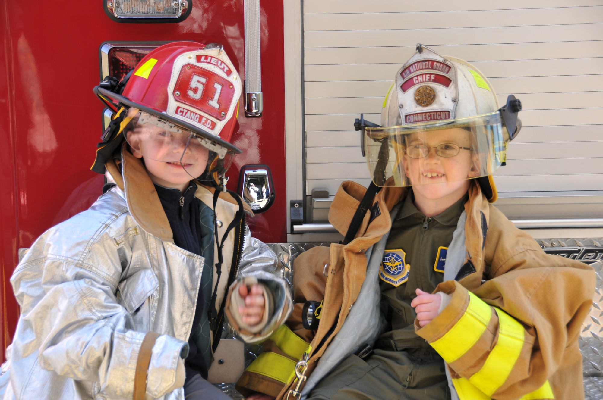 Logan Schoenhardt and his friend, Andrew Kerwin, pose wearing fire-fighting equipment during the Pilot for A Day Program at Bradley Air National Guard Base, East Granby, Conn., May 3, 2013. (Air National Guard photo by Senior Airman Jennifer Pierce/Released)