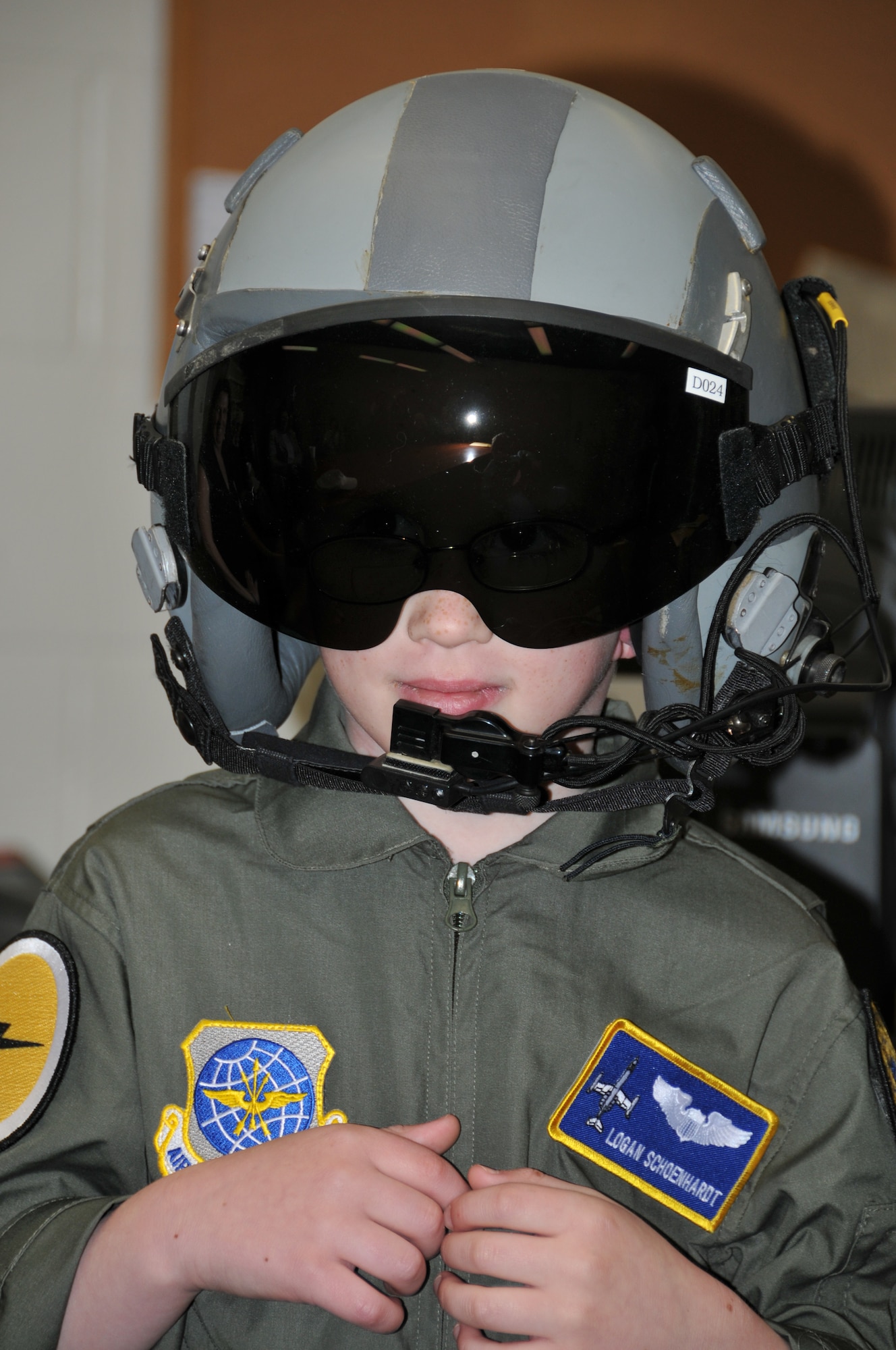 Logan Schoenhardt tries on a pilot's helmet during the Pilot for A Day Program at Bradley Air National Guard Base, East Granby, Conn., May 3, 2013. (Air National Guard photo by Senior Airman Jennifer Pierce/Released)