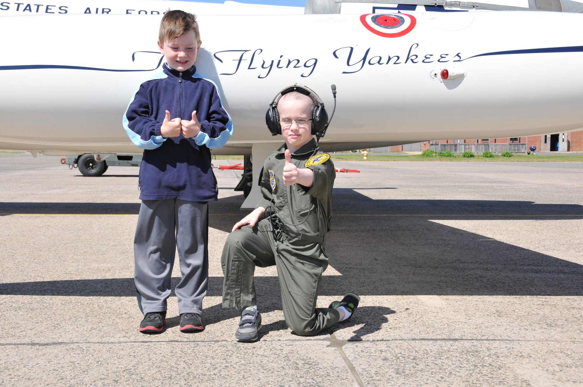 Logan Schoenhardt and his friend, Andrew Kerwin, give thumbs up in front of a C-21 during the Pilot for A Day Program at Bradley Air National Guard Base, East Granby, Conn., May 3, 2013. (Air National Guard photo by 1st Lt. Dawn Surprenant/Released)