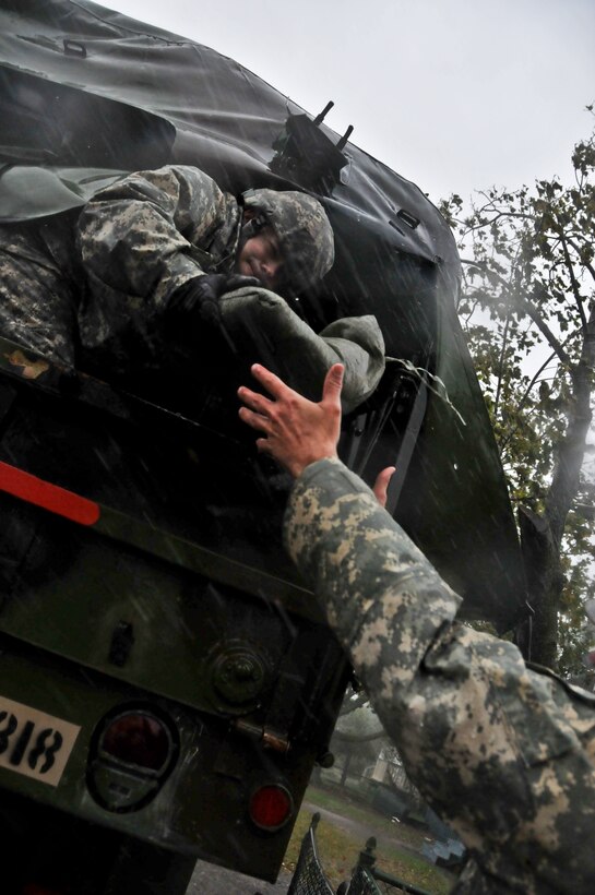 New Jersey Army National Guardsman Staff Sgt. Kenneth Williams hands sand bags out the back of a M35 2 1/2 ton cargo truck Oct. 29, 2012, in Atlantic City, N.J., in support of local residents during hurricane Sandy. (U.S. Air Force photo/Tech. Sgt. Matt Hecht)