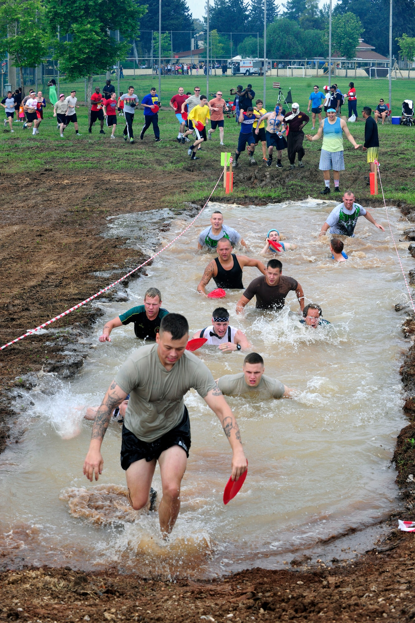 Members of Team Incirlik race through a 5-foot deep mud pit during the Ultimate Dirty Dash 3 May 18, 2013, at Incirlik Air Base, Turkey. Participants had to endure 21 separate obstacles during the event. (U.S. Air Force photo by Senior Airman Anthony Sanchelli/Released)
