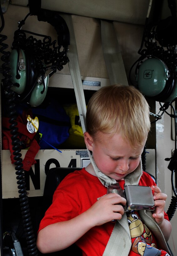 A child buckles himself into a Maryland State Police helicopter static display during the National Police Week Tactical First Responders Demonstration on May 17, 2013 at Joint Base Andrews, Md. (U.S. Air Force photo/ Airman 1st Class Nesha Humes)