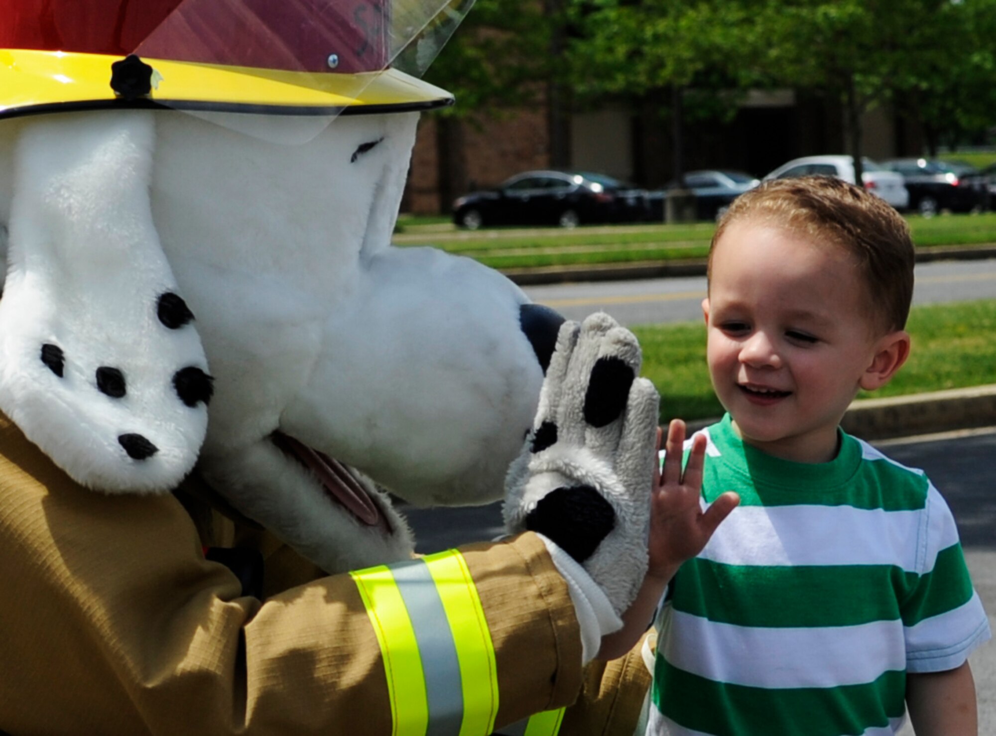 Sparky the Fire Dog, 11th Civil Engineering Squadron fire prevention correspondent, high fives a boy during the National Police Week Tactical First Responders Demonstration on May 17, 2013 at Joint Base Andrews, Md. (U.S. Air Force photo/Airman 1st Class Nesha Humes)