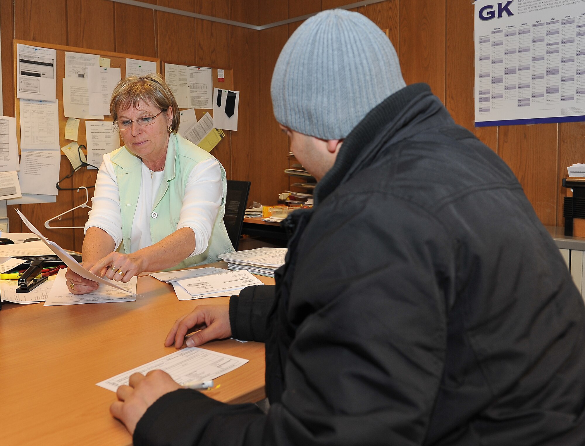 Heide Schmitt, international law judge advocate, explains legal documentation to Daniel Aponte,86th Force Support Squadron, April 7, 2013, Ramstein Air Base, Germany. Legal technicians act as a go-between for the German law and U.S. personnel. (U.S. Air Force photo/Airman 1st Class Dymekre Allen)   
