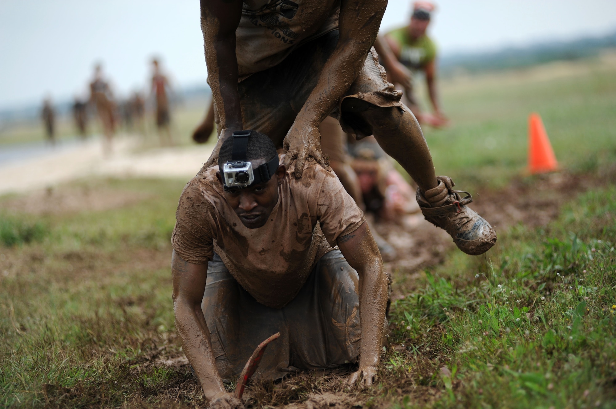 Eric Summers, 39th Air Base Wing, waits as his partner executes the leap frog obstacle during the Ultimate Dirty Dash 3 May 18, 2013, at Incirlik Air Base, Turkey. Teams competed in a race through 21 different stations, covering themselves in mud throughout the 5K course. (U.S. Air Force photo by Senior Airman Jarvie Z. Wallace/Released) 