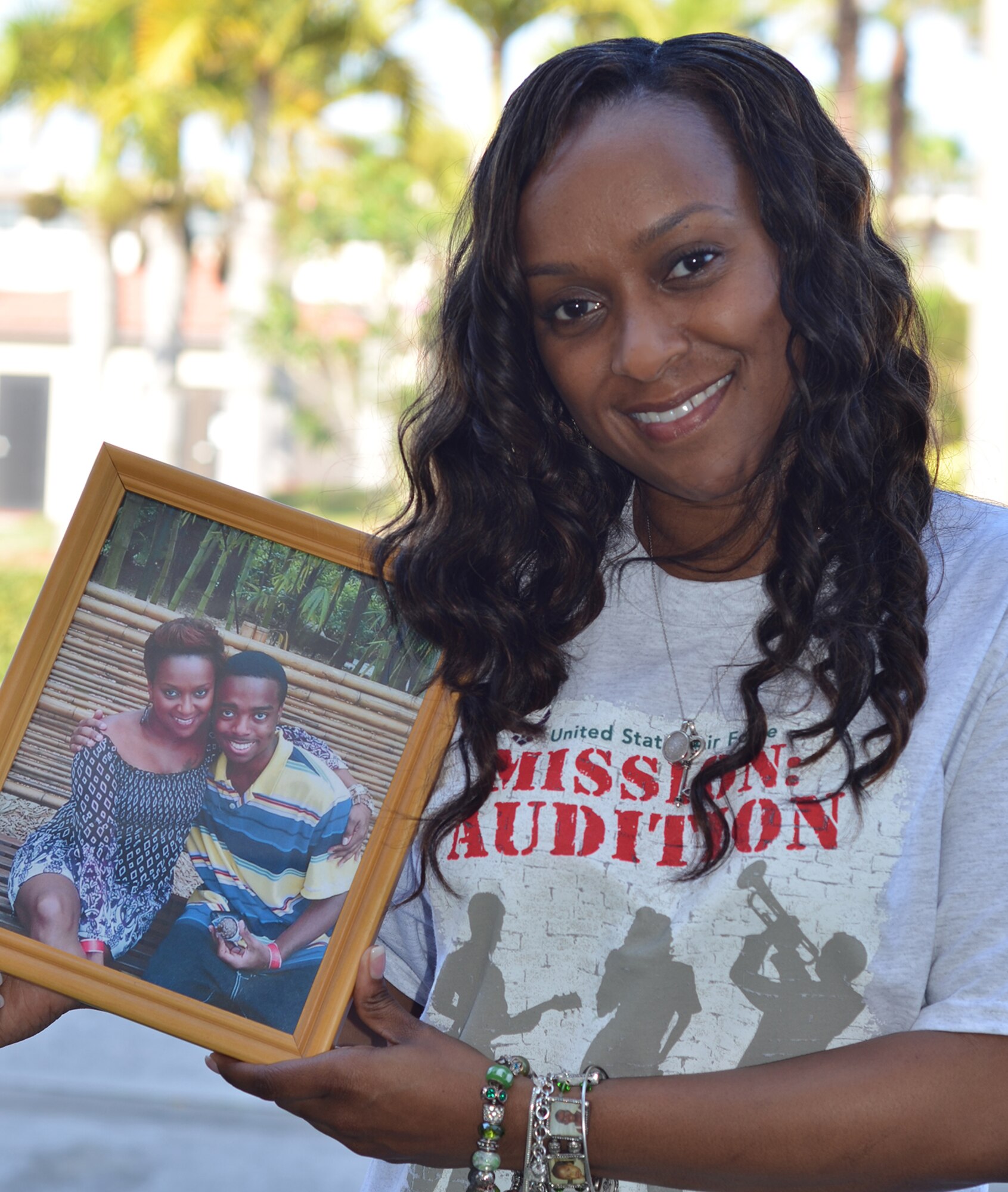 Tech. Sgt. Altrameise Myers, an information management craftsman with the 920th Rescue Wing, Patrick Air Force Base, Fla., poses with a photo of her late son who passed away in 2012. Myers' grief helped to melt away her stage fright, which led to an invitation to audition for the Air Force's Tops in Blue entertainment troupe. (Maj. Cathleen Snow)