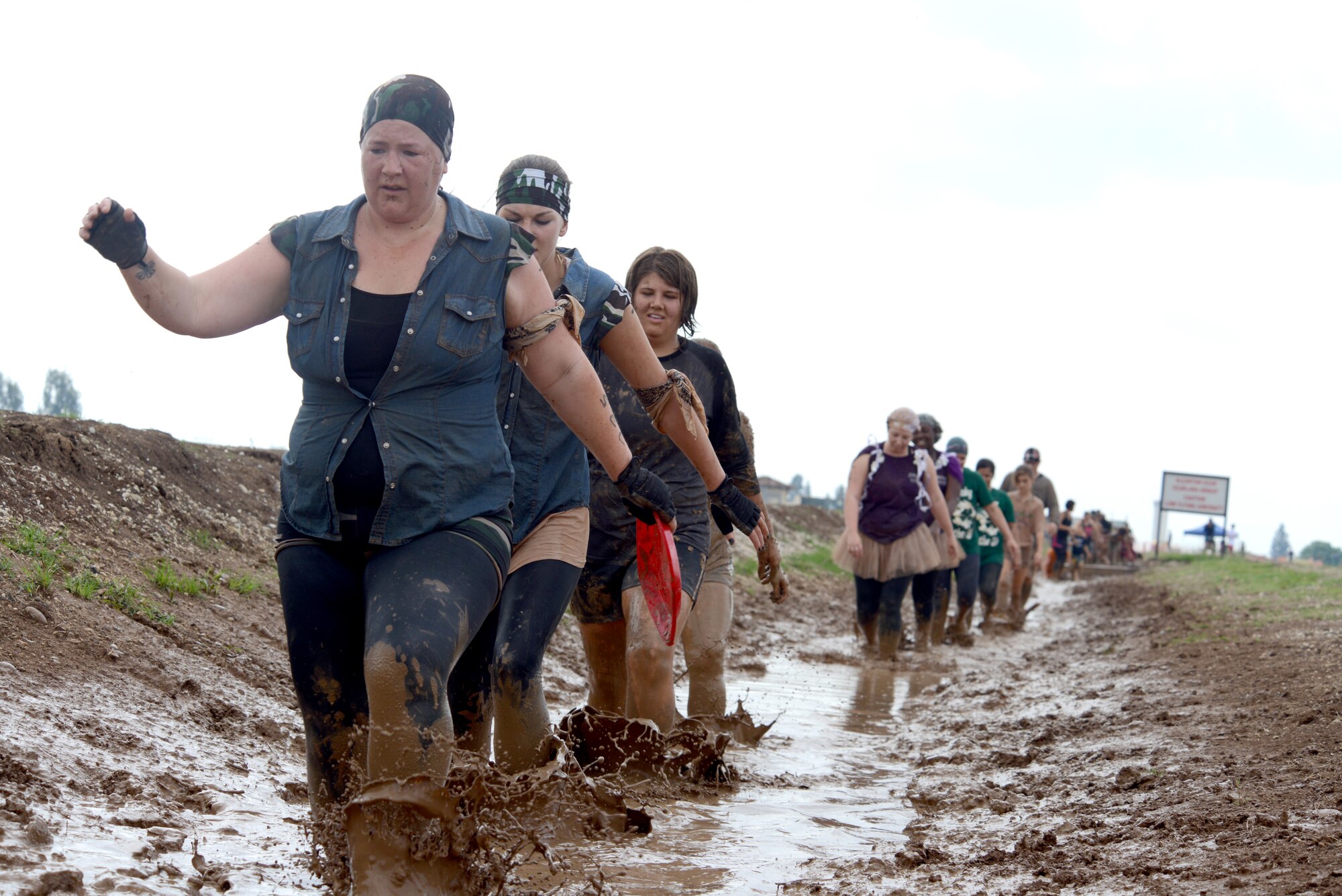 Participants in Ultimate Dirty Dash 3 trudge through a muddy ditch for one of the event’s challenges May 18, 2013, at Incirlik Air Base, Turkey. Several teams competed in the race through 21 different stations, covering themselves in mud throughout the 5K course. (U.S. Air Force photo by Tech. Sgt. Dallas Edwards/Released)