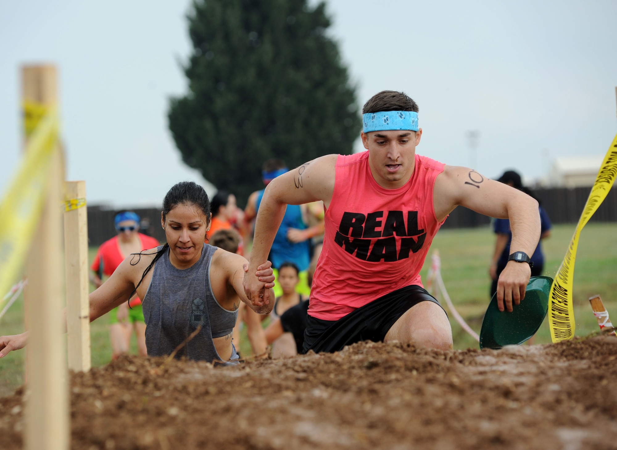 Claudia Carrasco and Emmanuel Villarreal, 39th Security Forces Squadron, traverse a mud pit and a dirt mound during the Ultimate Dirty Dash 3 May 18, 2013, at Incirlik Air Base, Turkey. Teams competed in a race through 21 different stations, covering themselves in mud throughout the 5K course. (U.S. Air Force photo by Senior Airman Jarvie Z. Wallace/Released)  