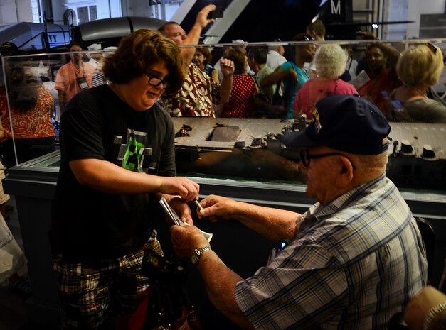 A World War II veteran signs an autograph during the final reunion for the USS Franklin (CV 13) May 17, 2013, aboard USS Yorktown (CV 10) at Patriots Point Naval and Maritime Museum, Mount Pleasant, S.C. In honor of the reunion, Patriots Point hosted a series of events and educational programs throughout the day to allow the public an opportunity to speak with and hear from the veterans. (U.S. Air Force photo/Staff Sgt. Anthony Hyatt)