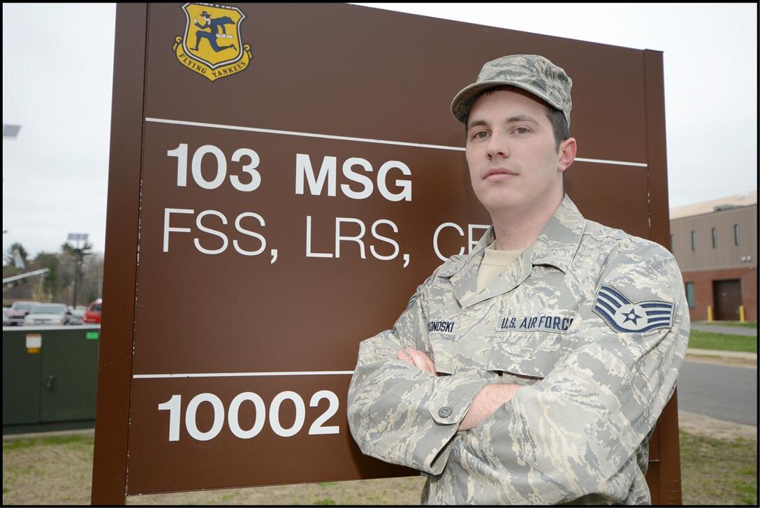 Staff Sgt. Dustin Wonoski, a member of the 103rd Logistics Readiness Squadron, stands in front of a building sign at Bradley Air National Guard Base, East Granby, Conn. Wonoski put service before self on April 15, 2013, when he found himself in the middle of the Boston Bombing. (Air National Guard photo by Tech. Sgt. Joshua Mead/Released)