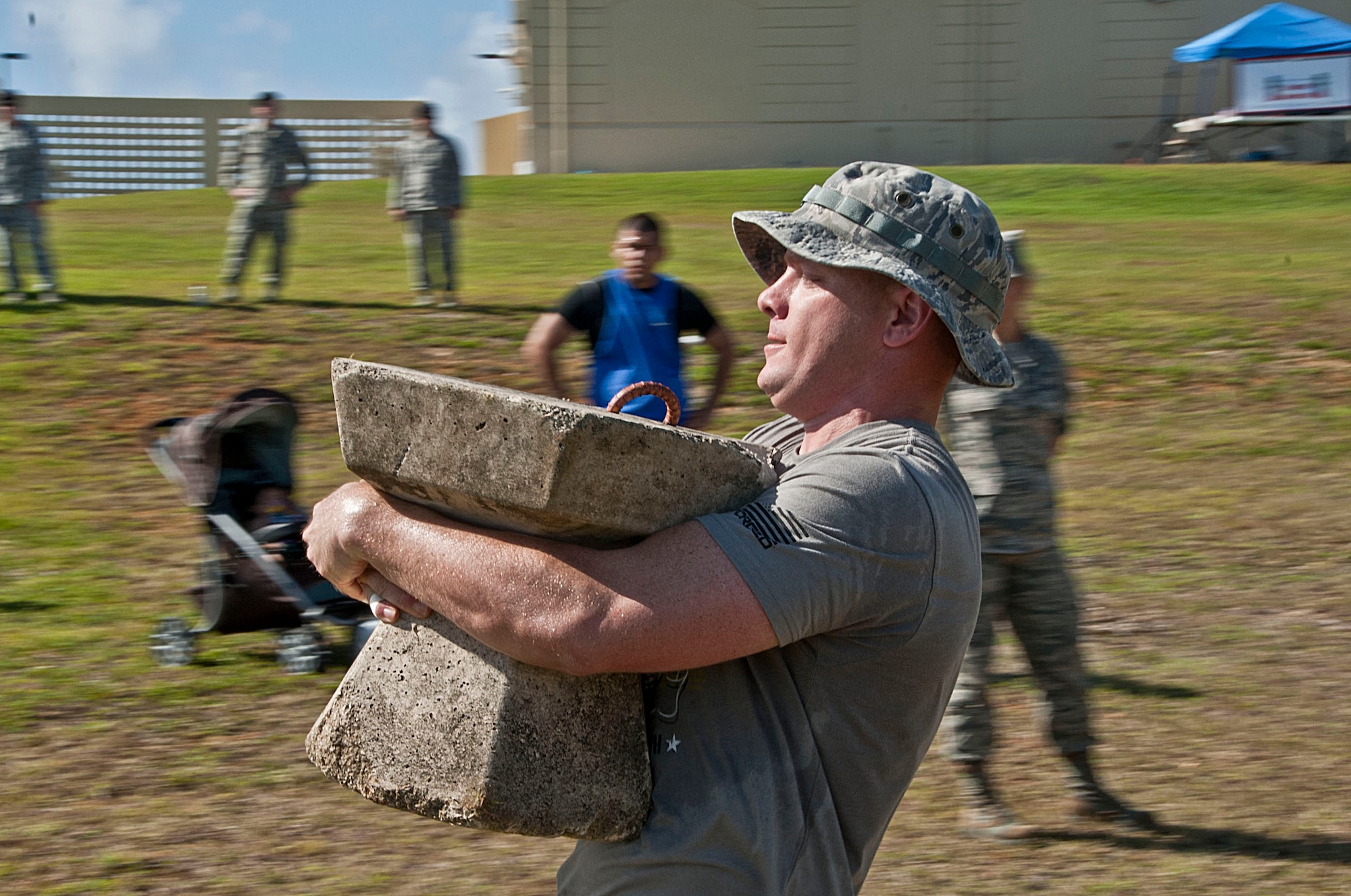 1st Lt. Brian Slater, 36th Security Forces Squadron assistant operations officer, runs with a cement block in the Strongman Competition at Andersen Air Force Base, Guam, May 15, 2013. The Strongman Competition was held in honor of National Police Week which occurs each year during the week of May 15 in recognition of the service and sacrifice of members of U.S. law enforcement agencies. (U.S. Air Force photo by Airman 1st Class Adarius Petty/Released)