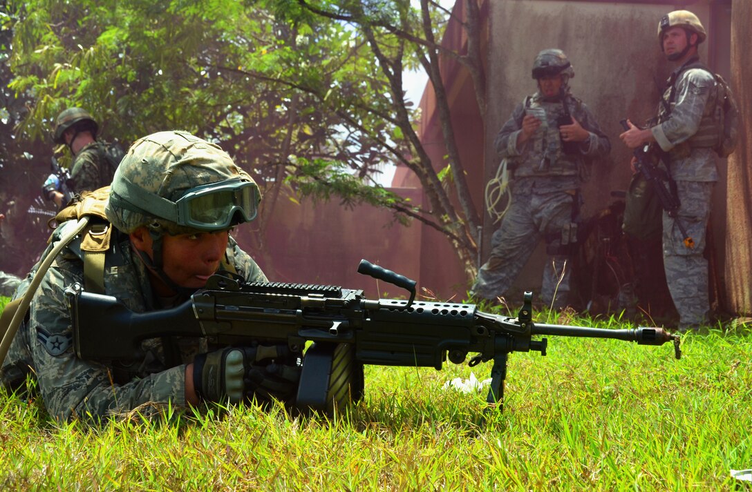 Airman 1st Class Tupou Ainuu, 168th Security Forces Squadron fire team member from Eielson Air Force Base, Alaska, secures the flank with an M249 light machine gun during an urban warfare scenario as part of the basic security operations course at Andersen South, Guam, May 17, 2013. The Pacific Regional Training Center trains frontline defenders from all bases assigned to Pacific Air Forces on U.S. Central Command and regional training requirements so they can deploy as well as utilize trained skills at their home stations. (U.S. Air Force photo by Staff Sgt. Benjamin Wiseman/Released)