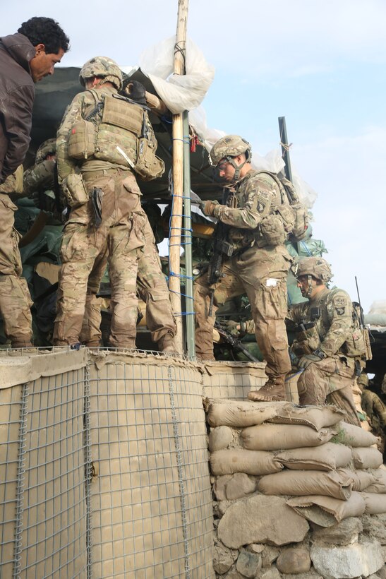 U.S. soldiers coordinate with Afghan guards in the Hesarak village of Nangarhar province, Afghanistan, May 14, 2013. The guard towers are set up to provide overwatch security for the district center.