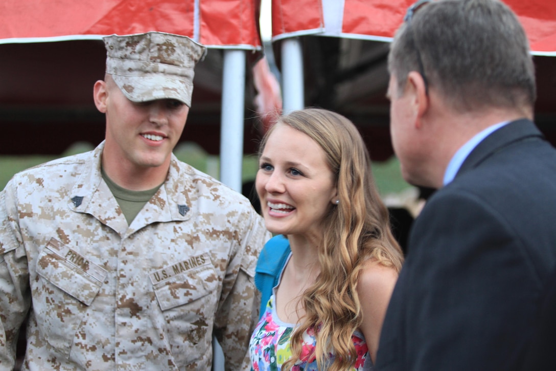 Sgt. Christopher Prior, left, a 3rd Marine Aircraft Wing noncommissioned officer and Cedar Rapids, Iowa native, and his wife, Paige, center, greet guests after an evening colors ceremony honoring military spouses aboard Marine Corps Air Station Miramar, Calif., May 21. The ceremony paid homage to spouses who serve the military from the home front by supporting the men and women on the front lines.