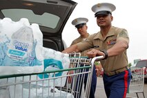 Recruiting Substation Roseville's Sgt. Phillip Sze watches fellow recruiter Staff Sgt. Van Tulmau transport part of a $200 water donation for H2OK May 22. Radio station 101.3 KDWB, Rainbow Foods and 101 Transport Inc. coordinated the event to bring tornado relief to Oklahoma. Donations will be shipped via semi to Moore, Okla., on Thursday. For additional imagery from the event, visit www.facebook.com/rstwincities.