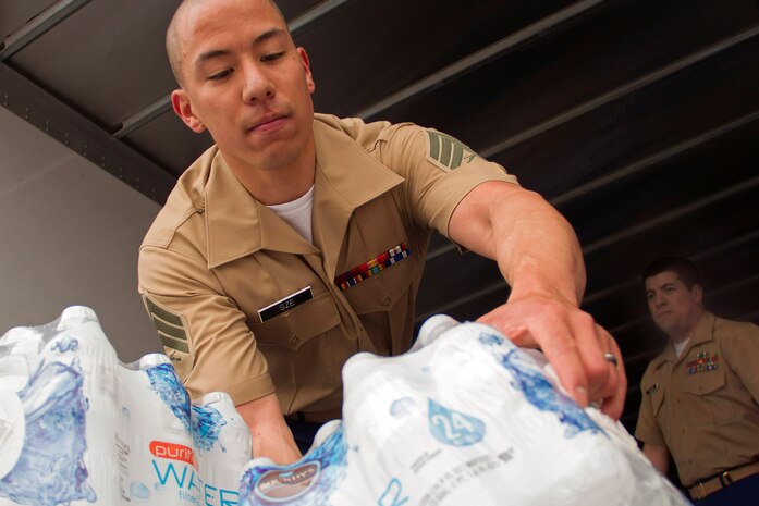 Recruiting Substation Roseville's Sgt. Phillip Sze prepares to toss a case of water to Staff Sgt. Jowa Wildes after dropping off a $200 water donation for H2OK May 22. Radio station 101.3 KDWB, Rainbow Foods and 101 Transport Inc. coordinated the event to bring tornado relief to Oklahoma. Donations will be shipped via semi to Moore, Okla., on Thursday. For additional imagery from the event, visit www.facebook.com/rstwincities.