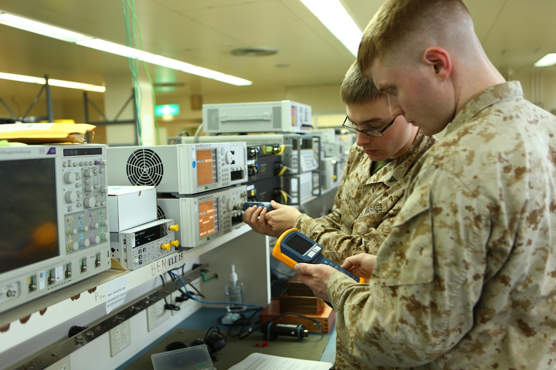 Lance Cpl. Justin W. Ivie, background, and Lance Cpl. Timothy R. Smith, test the fiber optics of the light-wave measurement system May 9 at the 3rd Maintenance Battalion calibration laboratory on Camp Kinser. Smith and Ivie are calibration technicians with 3rd Maintenance Bn., Combat Logistics Regiment 35, 3rd Marine Logistics Group, III Marine Expeditionary Force. 